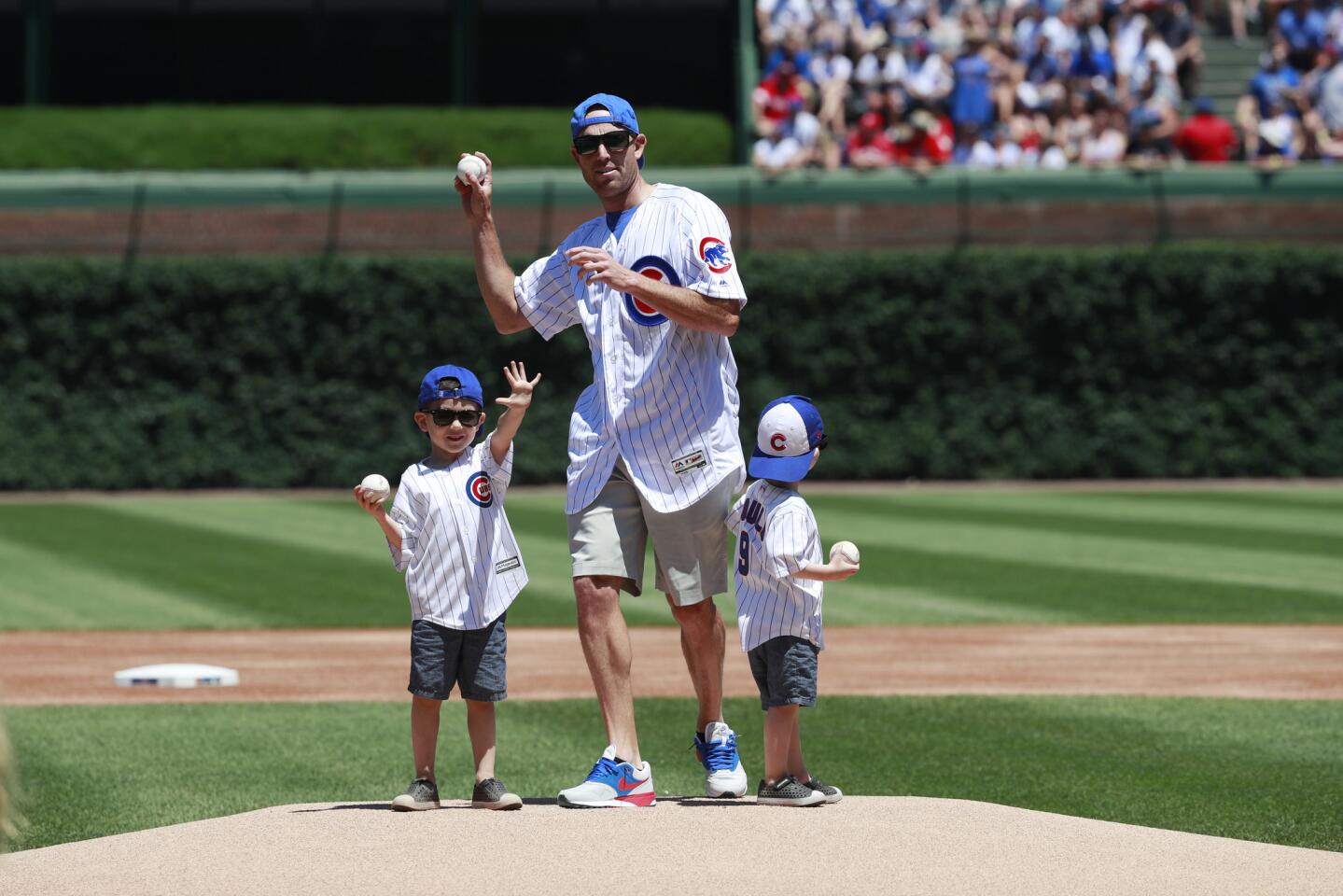 Former Bears kicker Robbie Gould, throws out the ceremonial first pitch before a Cubs-Reds game at Wrigley Field on July 7, 2018. With him are his two sons Griffin, 4, and Gavin, 3.