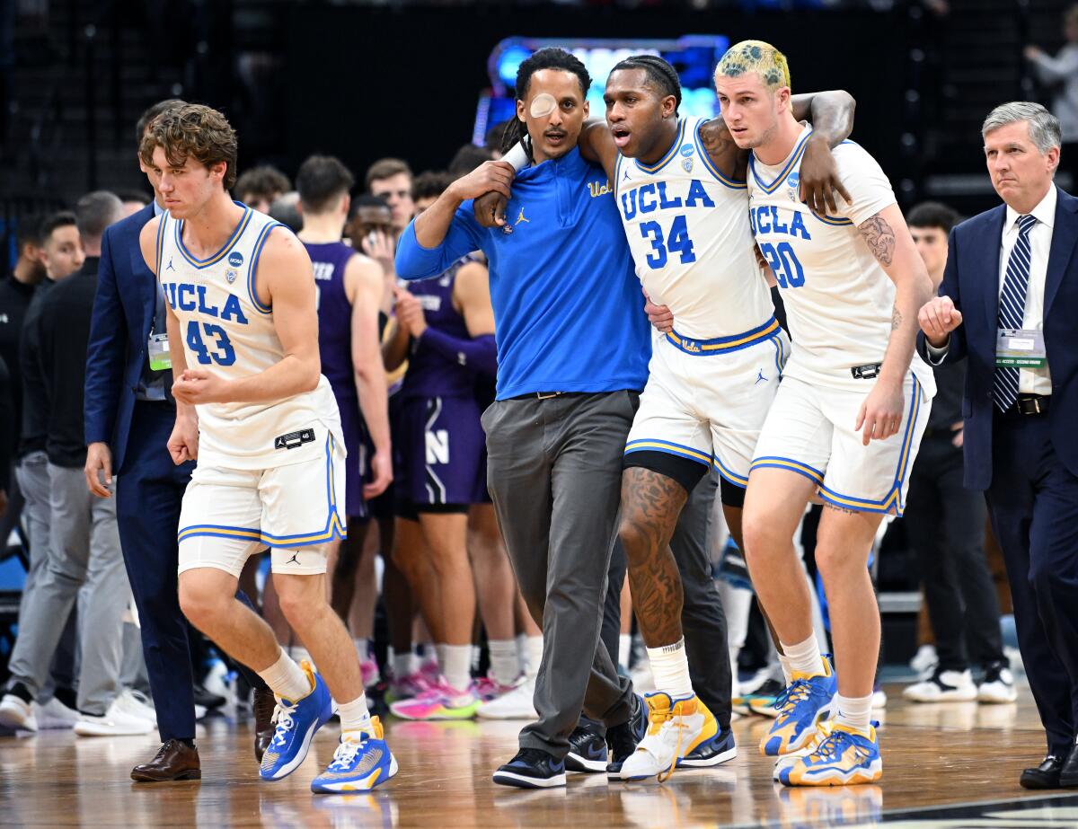 UCLA's David Singleton is helped off the court after injuring his ankle