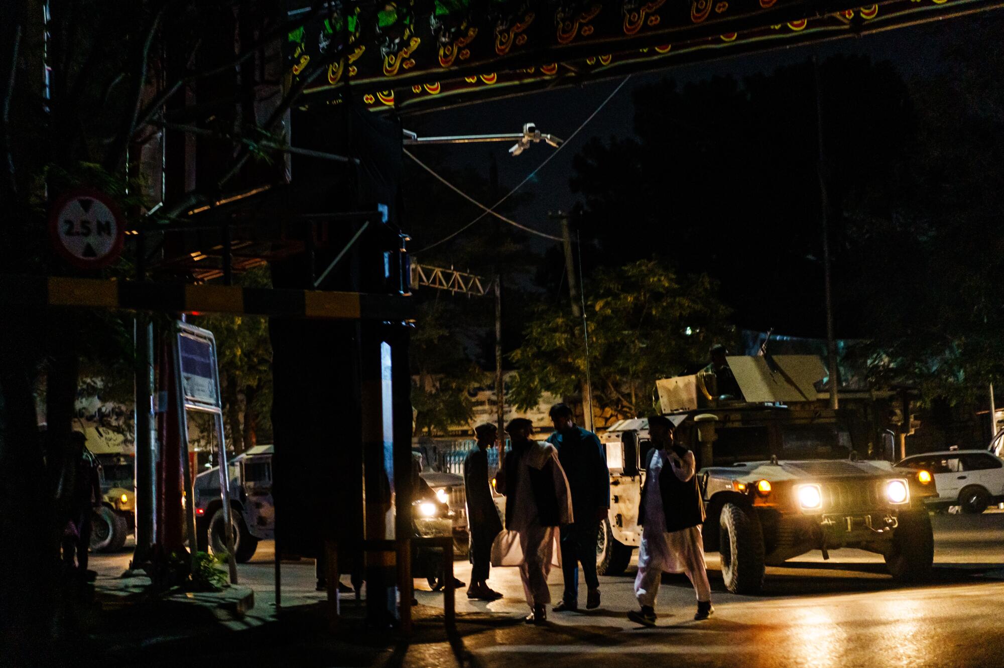 A military vehicle with militants patrols a street.