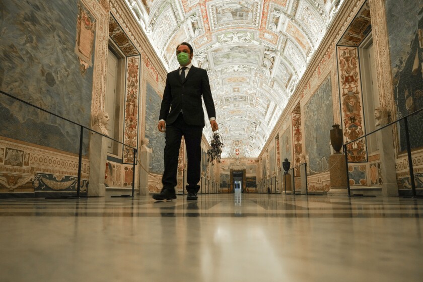 Gianni Crea, the Vatican Museums chief "Clavigero" key-keeper, holds a bunch of keys as he walks down the "Maps Aisle" to open the museum's rooms and sections, at the Vatican, Monday, Feb. 1, 2021. Crea is the “clavigero” of the Vatican Museums, the chief key-keeper whose job begins each morning at 5 a.m., opening the doors and turning on the lights through 7 kilometers of one of the world's greatest collections of art and antiquities. The Associated Press followed Crea on his rounds the first day the museum reopened to the public, joining him in the underground “bunker” where the 2,797 keys to the Vatican treasures are kept in wall safes overnight. (AP Photo/Andrew Medichini)