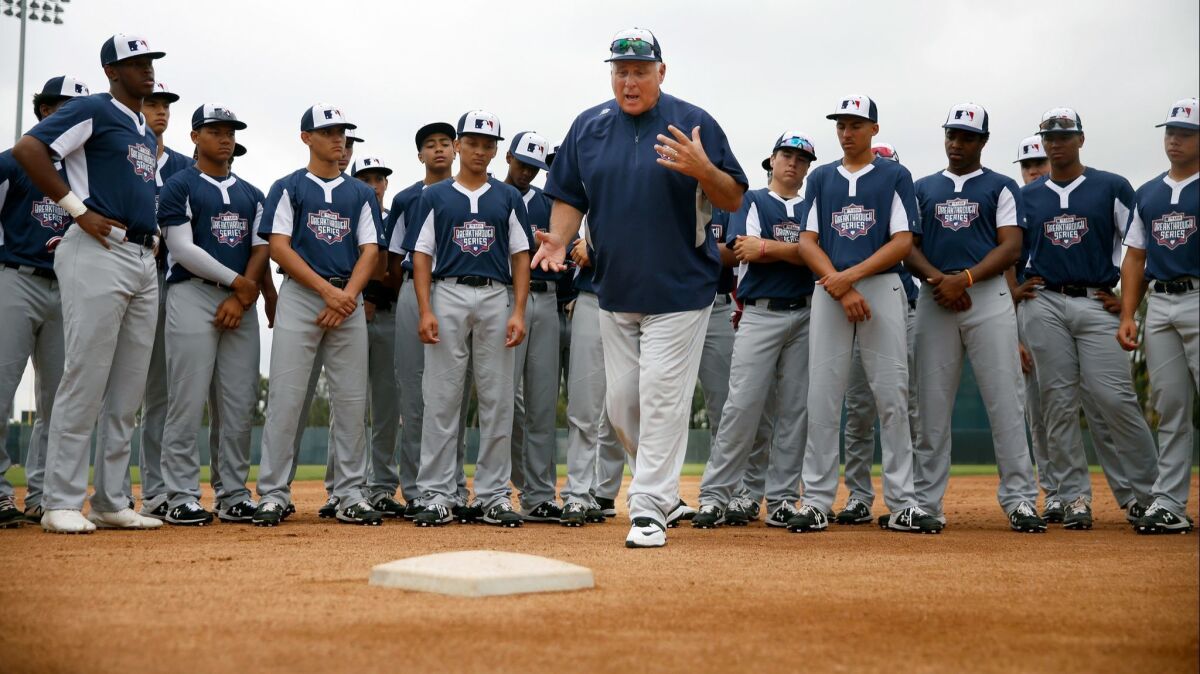 Mike Scioscia leads baseball players in a drill.