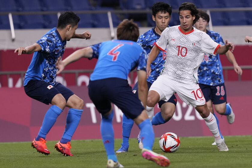 Mexico's Diego Lainez is challenged by Japanese players during a men's soccer match at the 2020 Summer Olympics, Sunday, July 25, 2021, in Saitama, Japan. (AP Photo/Martin Mejia)