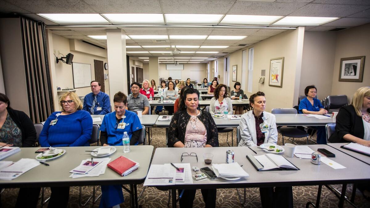 Nurses at St. Joseph Hospital in Orange participate in a breathing exercise. With recent shootings, fires and other disasters, nurses have started taking extra time to talk about their own mental health and that of other medical providers.