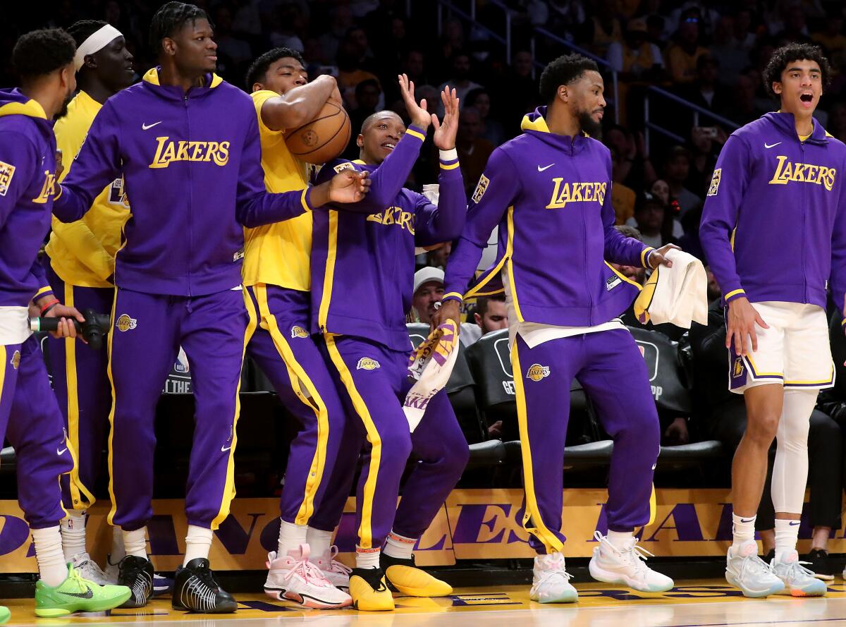 Lakers players on the bench celebrate a play on Sunday at Crypto.com Arena that helped the team clinch seventh in the West.