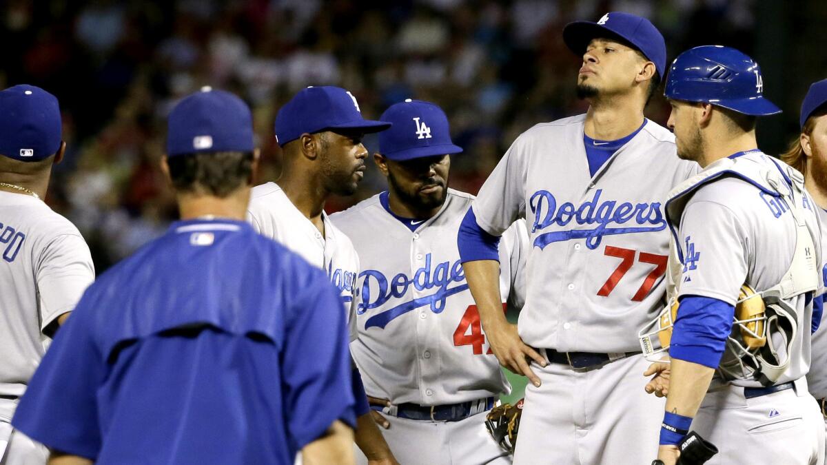 Dodgers starter Carlos Frias (77) stands on the mound with teammates as Manager Don Mattingly comes to replace his pitcher in the sixth inning on Monday night against Texas.