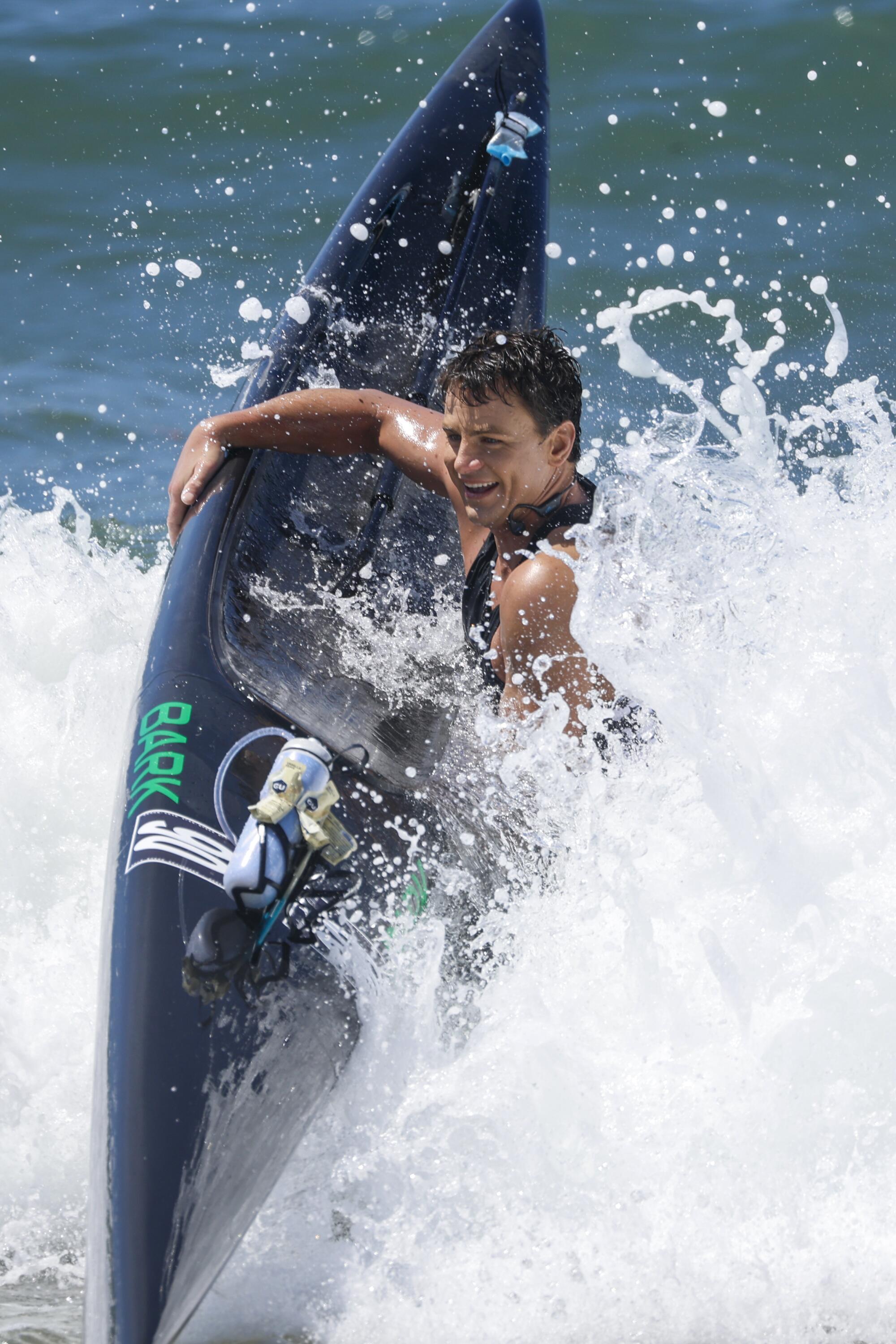 Robert Parch Jr. carries his paddleboard ashore after placing third in the 2023 Catalina Classic.