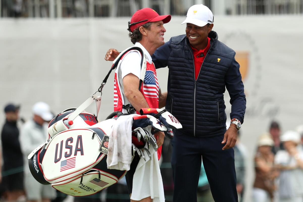 MELBOURNE, AUSTRALIA - DECEMBER 15: Playing Captain Tiger Woods of the United States team hugs caddie and swing coach of Patrick Reed of the United States team, Kevin Kirk, during Sunday Singles matches on day four of the 2019 Presidents Cup at Royal Melbourne Golf Course on December 15, 2019 in Melbourne, Australia. (Photo by Rob Carr/Getty Images) ** OUTS - ELSENT, FPG, CM - OUTS * NM, PH, VA if sourced by CT, LA or MoD **