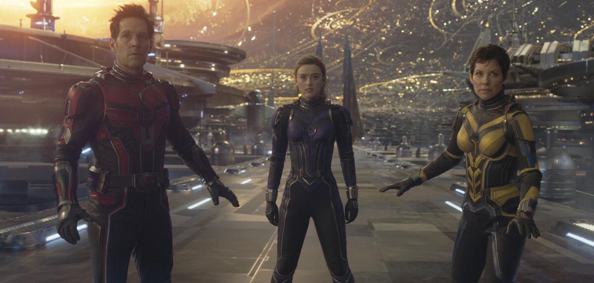 A man and two women wearing superhero uniforms and standing in a CGI landscape