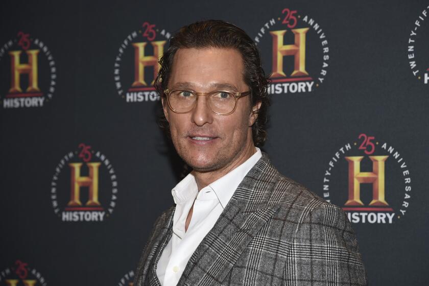 Matthew McConaughey wearing a plaid blazer and whit shirt and glasses at red carpet event