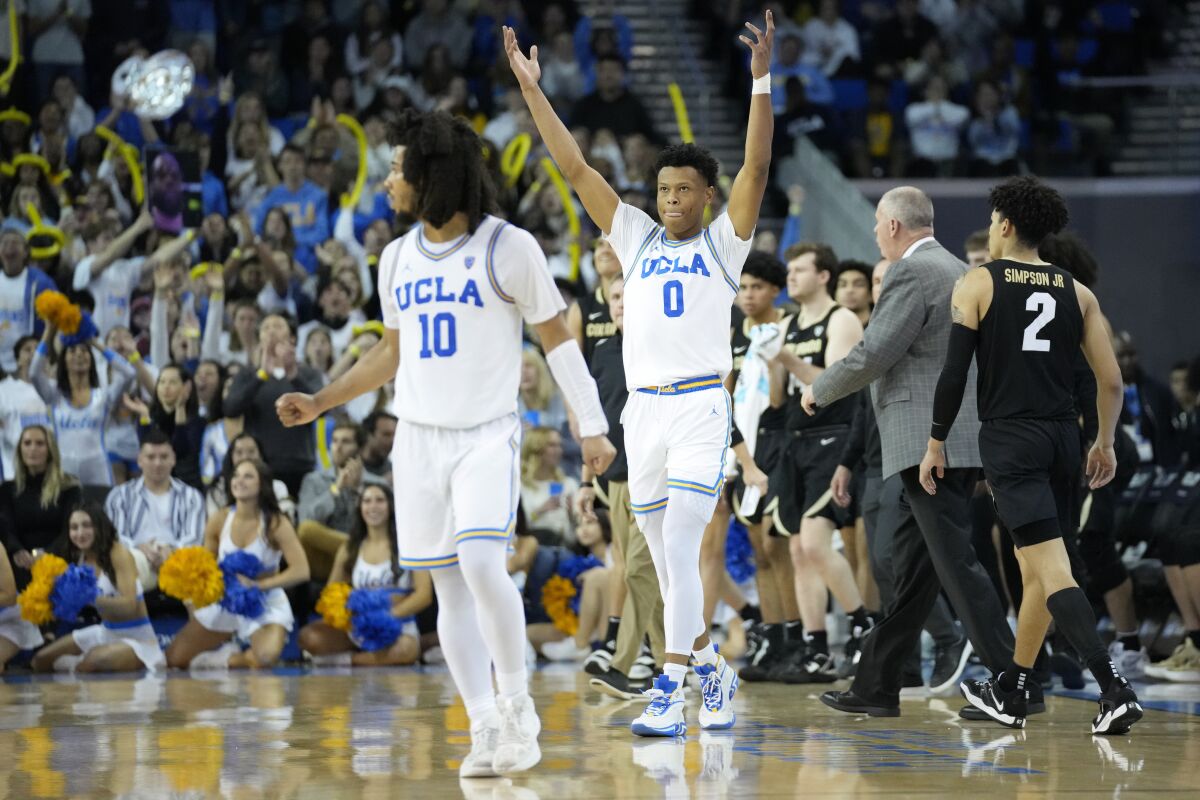 Bruins guard Jaylen Clark (0) celebrates with teammate Tyger Campbell during a timeout Saturday.
