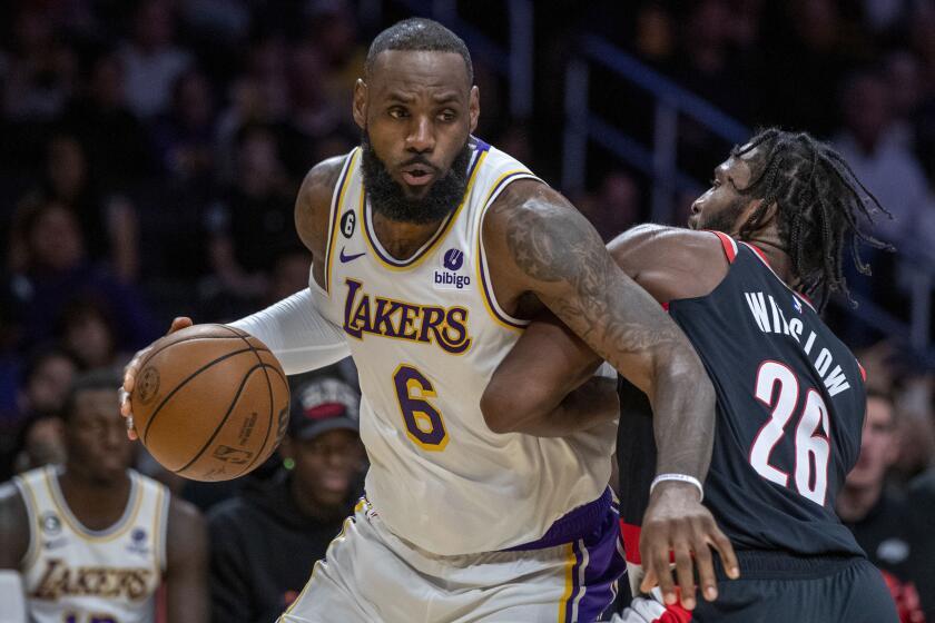Los Angeles Lakers forward LeBron James, left, drives around Portland Trail Blazers forward Justise Winslow.