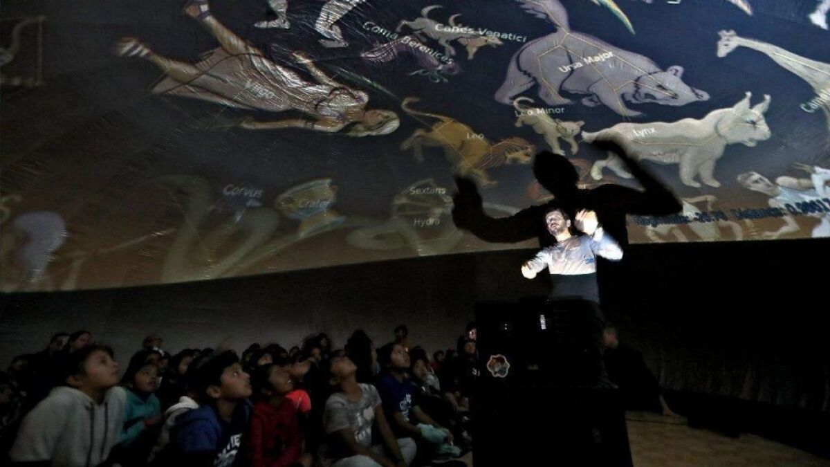 Students at Oak View Elementary School in Huntington Beach view constellations projected on the ceiling of an inflatable mobile planetarium Friday as presenter Mario Tomic talks about the night sky.
