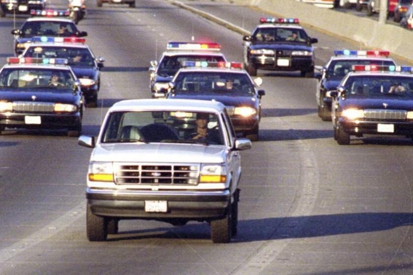 California Highway Patrol units chase Al Cowlings, who is driving the white Bronco, and O.J. Simpson, hiding in the rear, on the 91 Freeway shortly after Simpson was charged in slayings.
