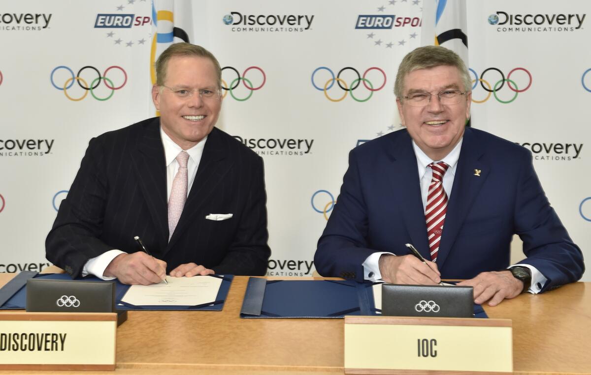 Discovery Communications President and CEO David Zaslav, left, and IOC President Thomas Bach sign an agreement in Lausanne, Switzerland, on Monday securing the European broadcast rights for four Olympics.