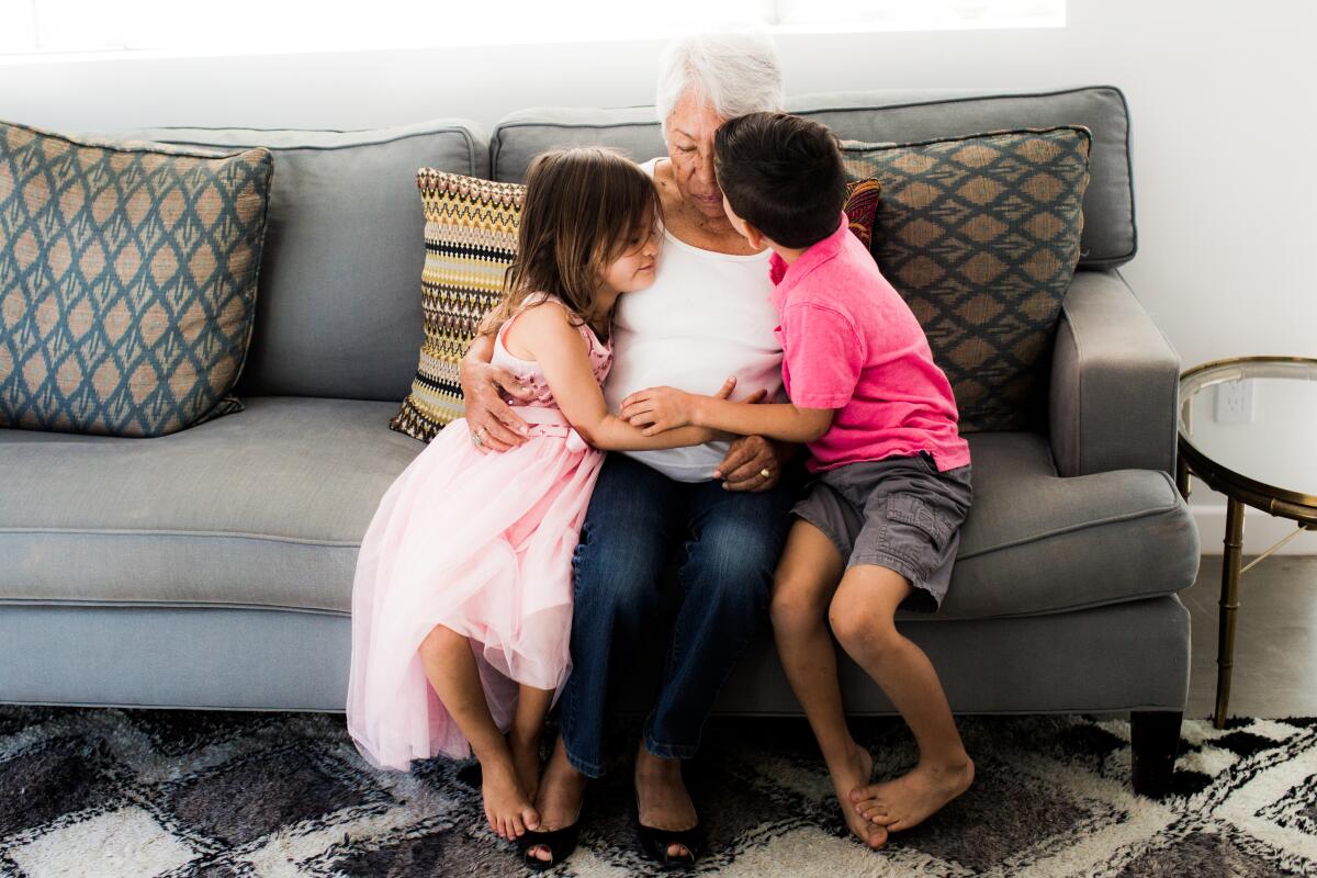 Norma Fabian Newton's two kids hugging their grandmother.