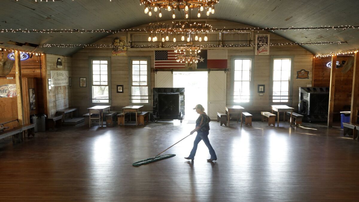 Jo Nell Haas sweeps the dance floor of the Twin Sisters Dance Hall, which her ancestors built in 1879 in Blanco, Texas. She holds dances the first Saturday of every month. (Katie Falkenberg / Los Angeles Times)