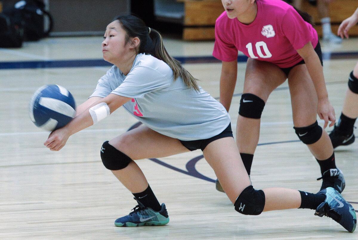 Burbank's Makayla Kim drops to hit a Crescenta Valley serve into play in a Pacific League girls' volleyball match at Crescenta Valley High School on Thursday, October 10, 2019.in a Pacific League girls' volleyball match at Crescenta Valley High School on Thursday, October 10, 2019. Both teams wore the exact same color pink jersey in honor of Breast Cancer Awareness month.