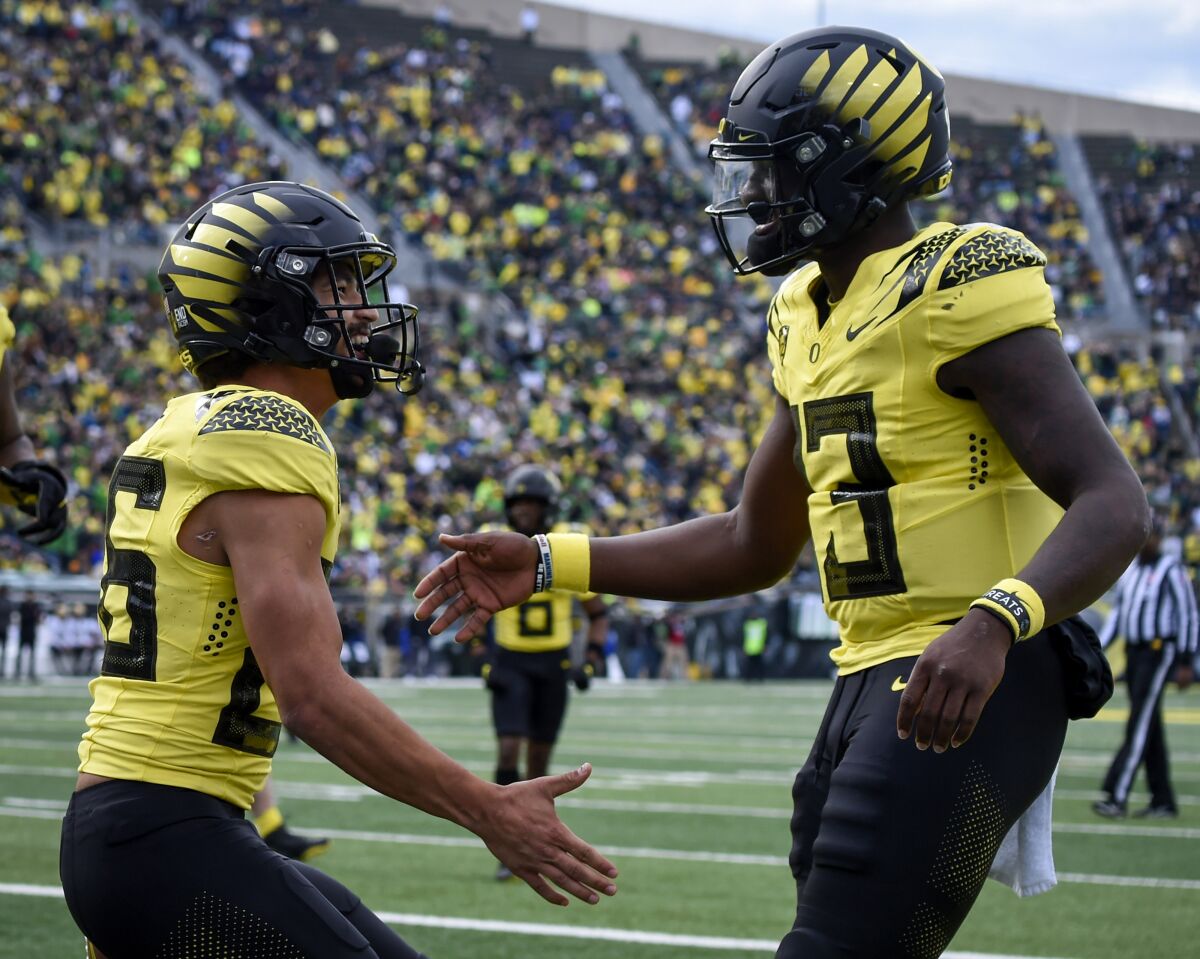 Oregon running back Travis Dye and quarterback Anthony Brown celebrate a touchdown.
