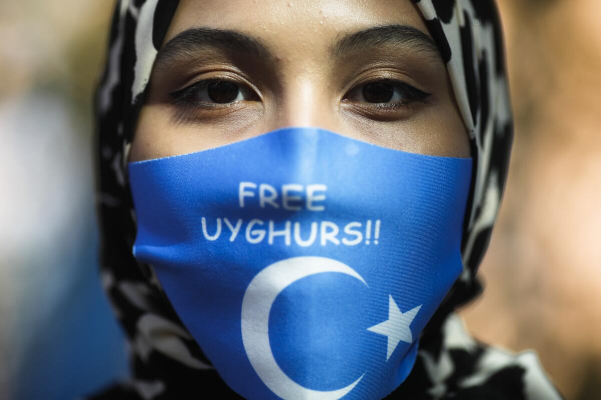Woman wearing mask with the words "Free Uyghurs"