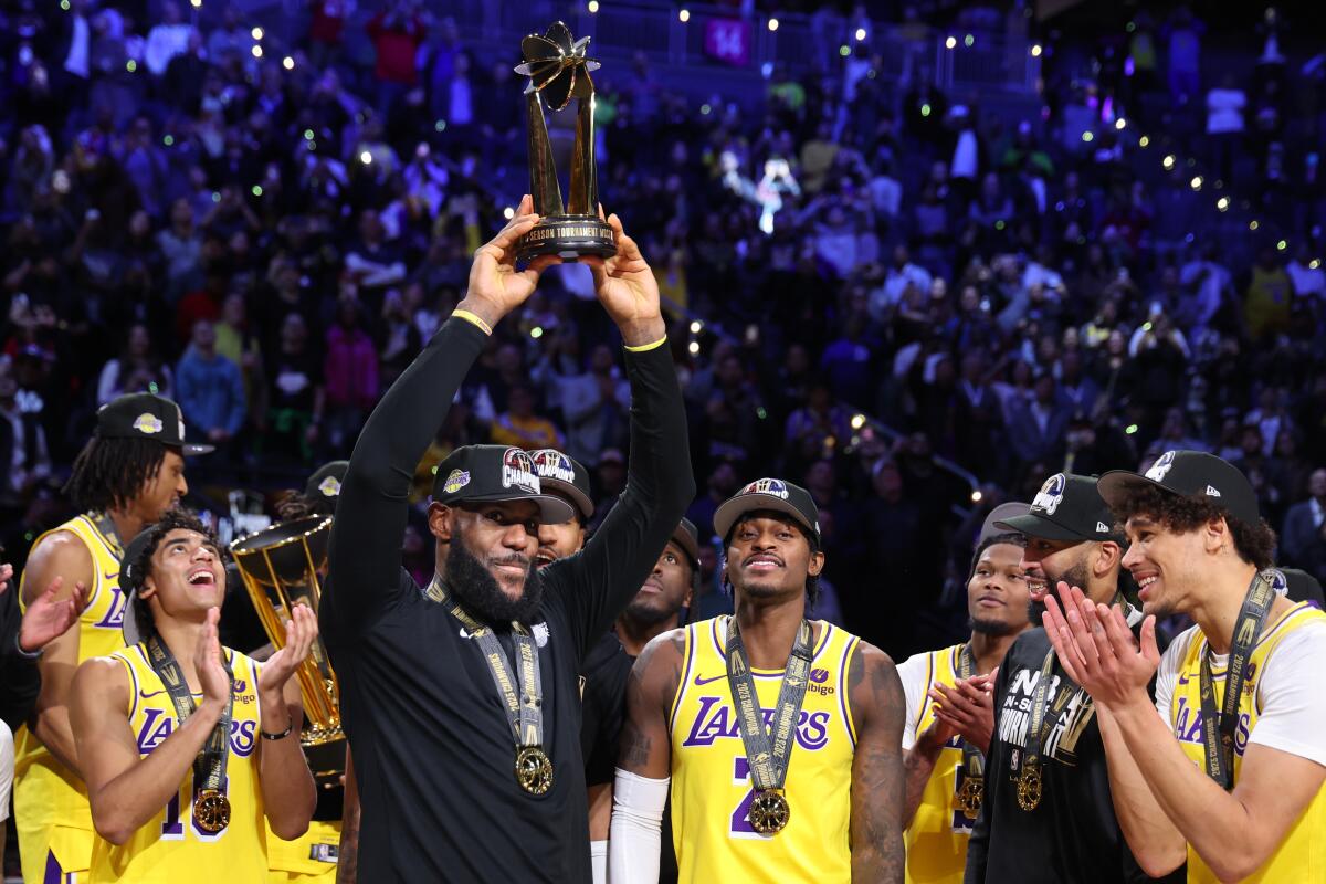 LeBron James celebrates with the NBA in-season tournament MVP award after the Lakers' 123-109 win over the Pacers.