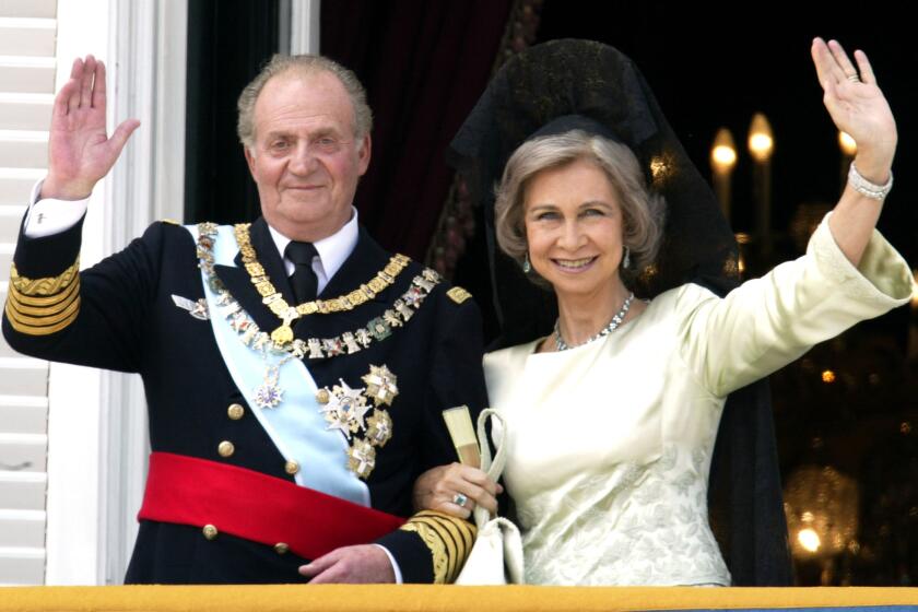 Spanish King Juan Carlos and Queen Sofia wave as they appear on the balcony of the royal palace after the wedding of their son, Crown Prince Felipe, in May 2004.