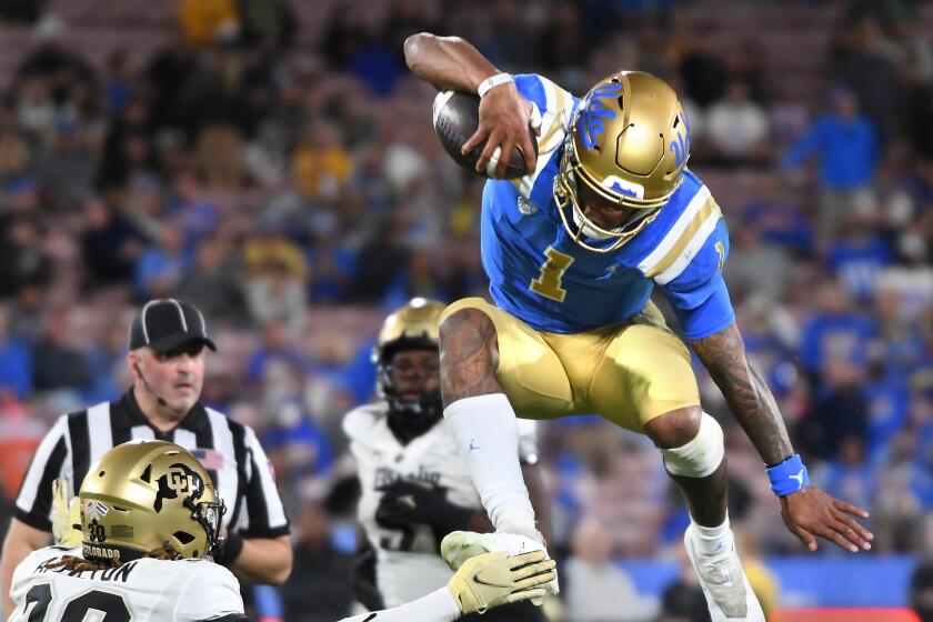 Pasadena, California November 13, 2021: UCLA quarterback Dorian Thompson-Robinson leaps.