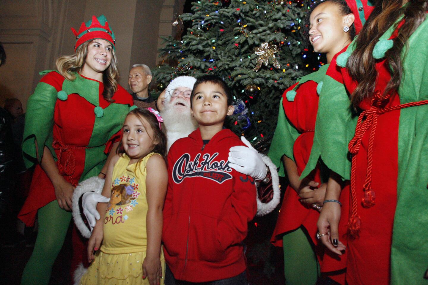 Linney Parra, 5 and Michael Cremona, 5, pose with Santa and his elves during a Christmas tree lighting which took place at Pasadena City Hall on Thursday, December 6, 2012.
