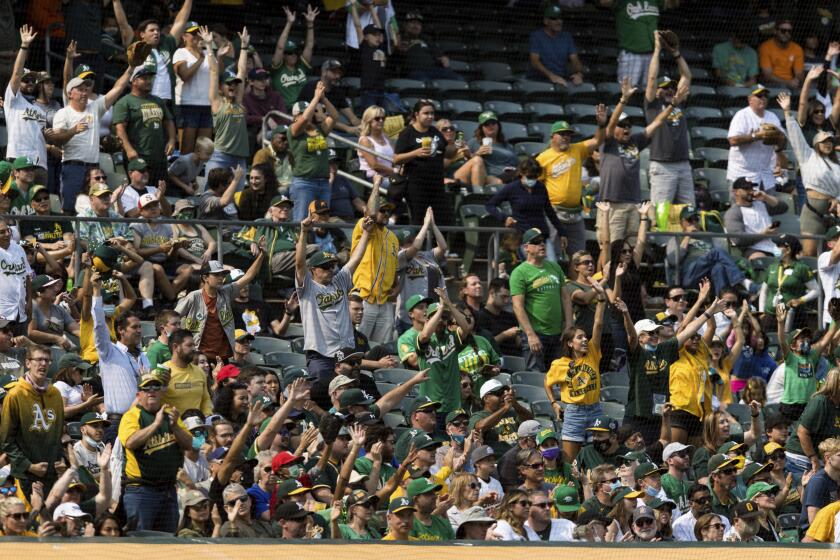 Spectators cheering in the fifth inning of a baseball game between the Oakland Athletics and the Houston Astros in Oakland, Calif., Saturday, Sept. 25, 2021. (AP Photo/John Hefti)