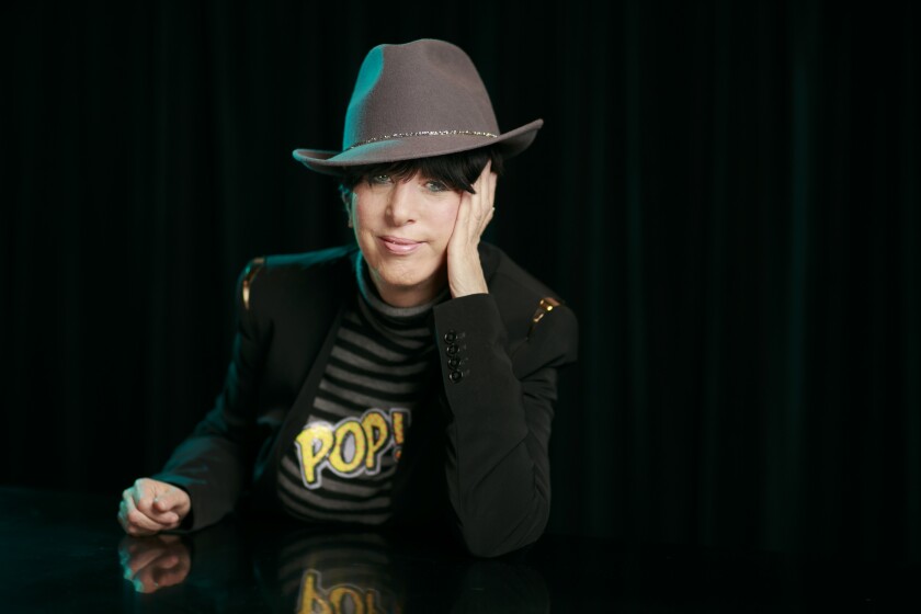 Songwriter Diane Warren wears a hat and shirt that reads Pop!  for a portrait.