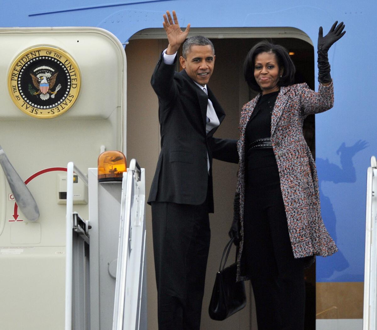 President Barack Obama and first lady Michelle Obama wave while boarding Air Force One before leaving O'Hare International Airport in Chicago, Ill.