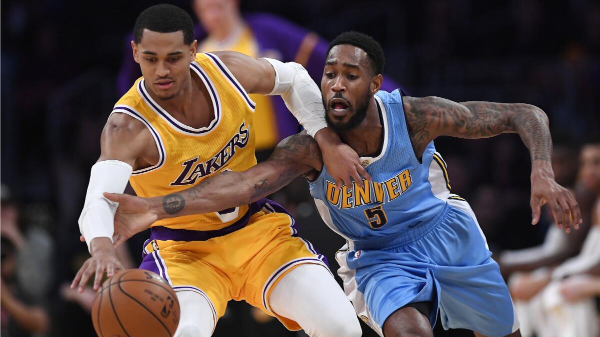 Lakers guard Jordan Clarkson, left, and Denver Nuggets guard Will Barton reach for a loose ball during the first half.