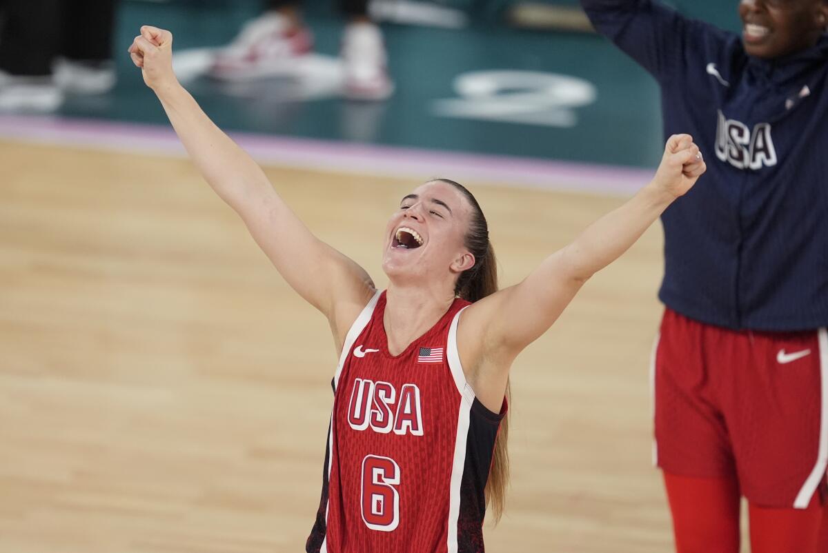 Sabrina Ionescu throws out her arms and cheers.