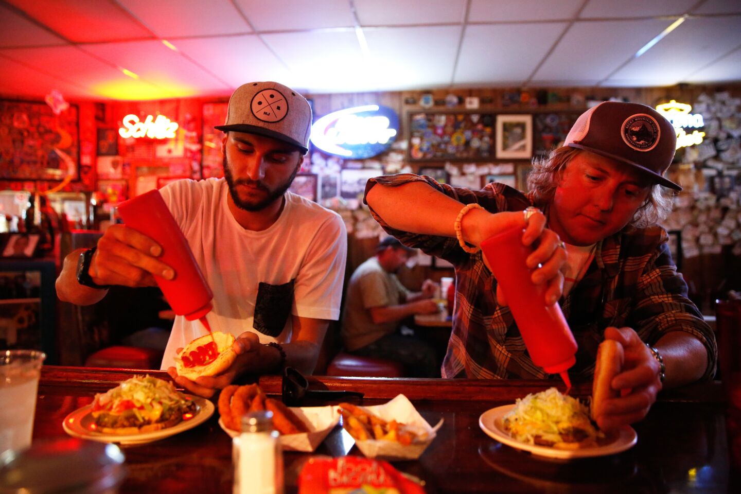 Friends Matt Fullam from Durango, CO and Anthony Appezzato from Denver, CO prepare to dig into their Green chile cheeseburgers at the Owl Bar and Cafe in San Antonio, NM