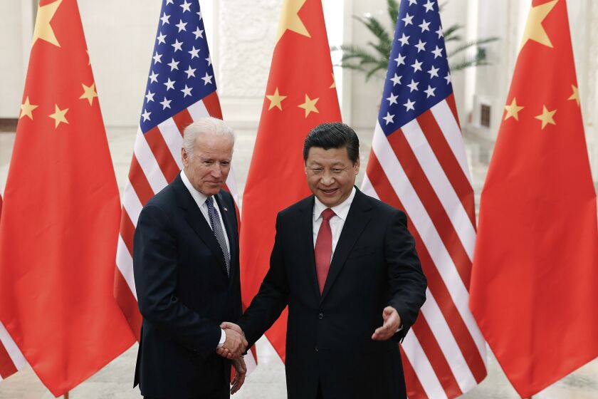 FILE - In this Dec. 4, 2013, file photo, Chinese President Xi Jinping, right, shakes hands with then U.S. Vice President Joe Biden as they pose for photos at the Great Hall of the People in Beijing. As Americans celebrate or fume over the new president-elect, many in Asia are waking up to the reality of a Joe Biden administration with decidedly mixed feelings. Relief and hopes of economic and environmental revival jostle with needling anxiety and fears of inattention. The two nations are inexorably entwined, economically and politically, even as the U.S. military presence in the Pacific chafes against China’s expanded effort to have its way in what it sees as its natural sphere of influence. (AP Photo/Lintao Zhang, Pool, File)
