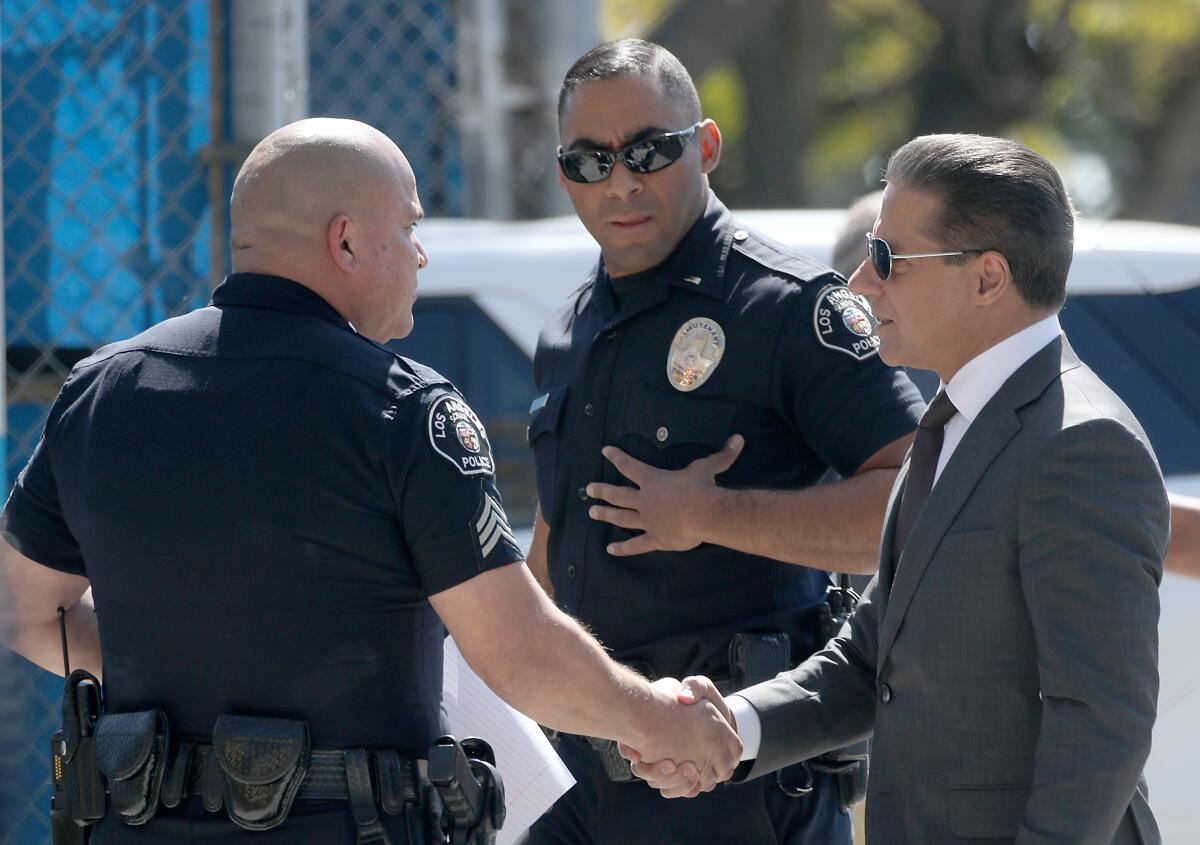 Alberto Carvalho shakes hands with a police officer