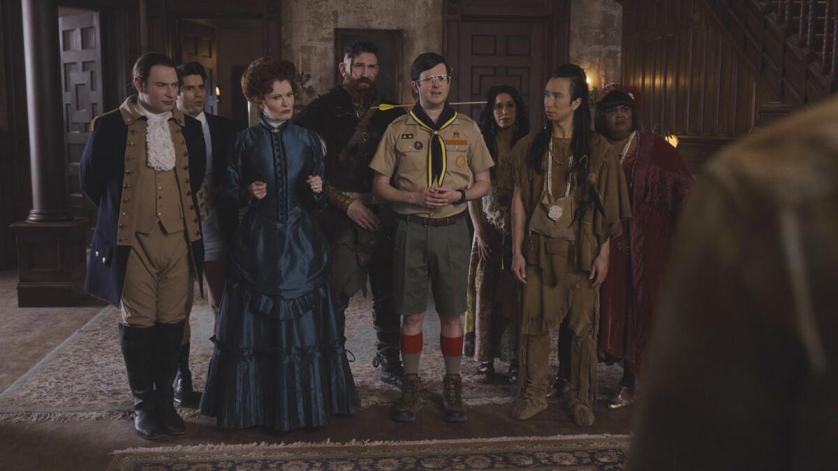 Spirits, including a soldier, a Victorian-era woman, a Boy Scout leader and a Native American, in a scene from "Ghosts."