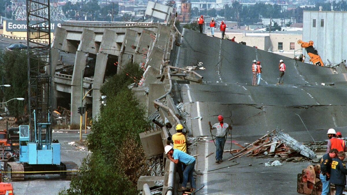 Magnitude 6.9: Workers check the damage to Interstate 880 in Oakland on Oct. 19, 1989. The freeway collapsed in the massive Loma Prieta earthquake. (Paul Sakuma / Associated Press)