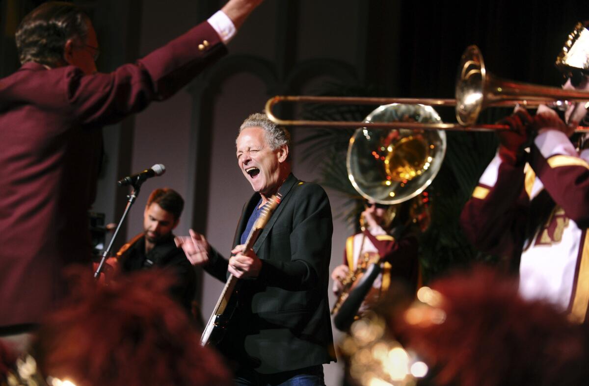 Fleetwood Mac's Lindsey Buckingham performs with the USC marching band at the university's Bovard Auditorium.