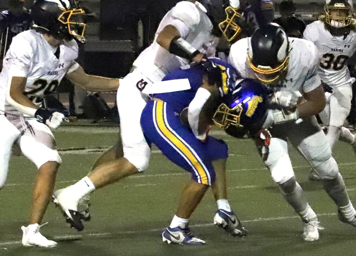 Marina's defensive line rallies to the football against Fountain Valley on Friday.