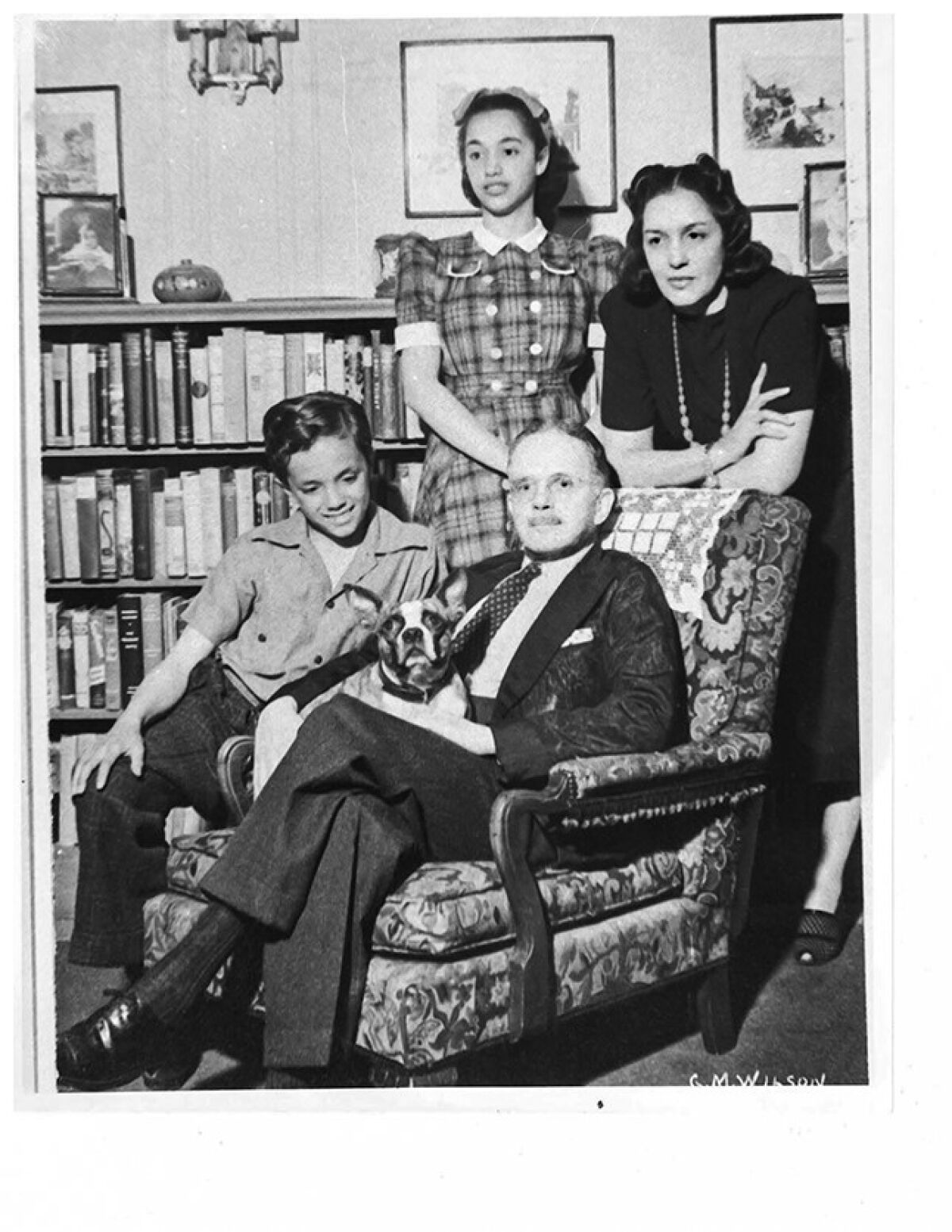 Walter F. White, seated in a living room, surrounded by his family.