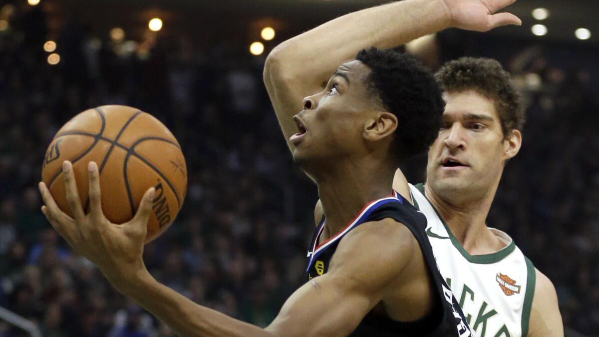 Clippers' Shai Gilgeous-Alexander drives past Milwaukee Bucks' Brook Lopez during the first half.