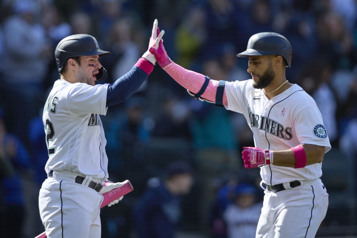 Seattle Mariners' Abraham Toro, right, is greeted at home plate by Luis Torrens after hitting a solo home run against the Tampa Bay Rays during the ninth inning of a baseball game, Sunday, May 8, 2022, in Seattle. (AP Photo/John Froschauer)
