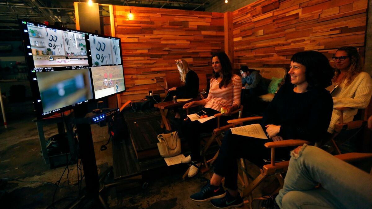 Emily Mraz, in black top, and producer Pollyanna Jacobs, to Mraz's right, work on a segment of "Tools, tools, tools" at Tastemade in Santa Monica.