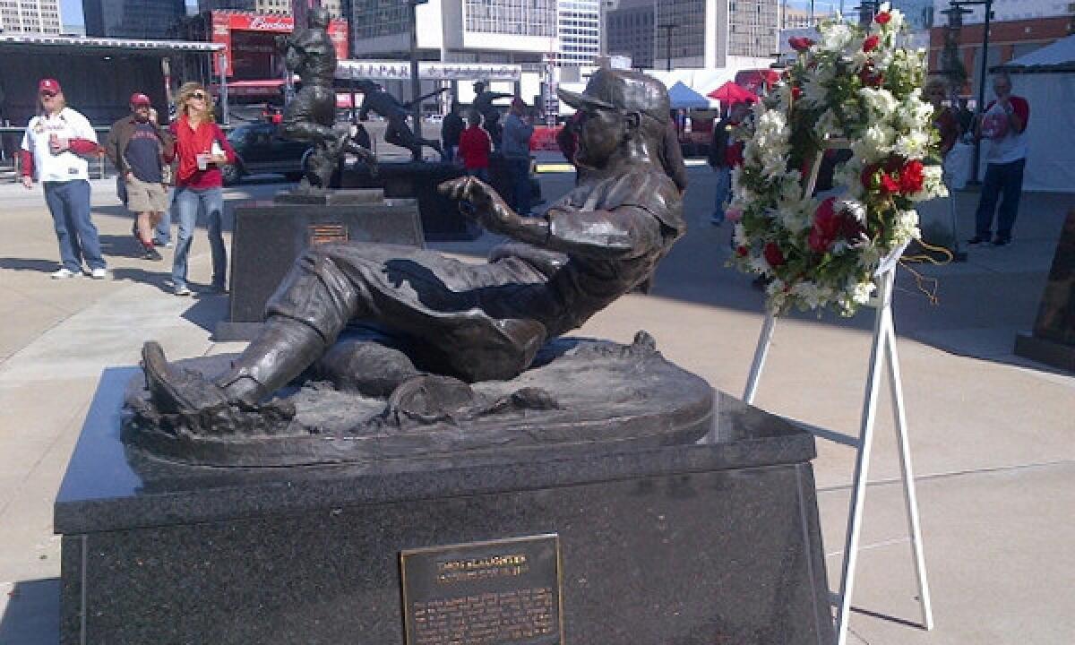 A wreath stands next to a statue honoring Cardinals great Enos Slaughter outside Busch Stadium in St. Louis on Saturday.