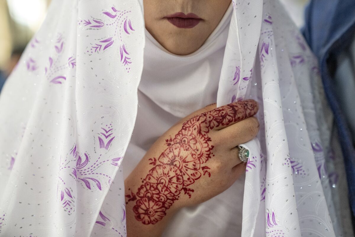 A close-up of an Afghan bride's mouth and hand.