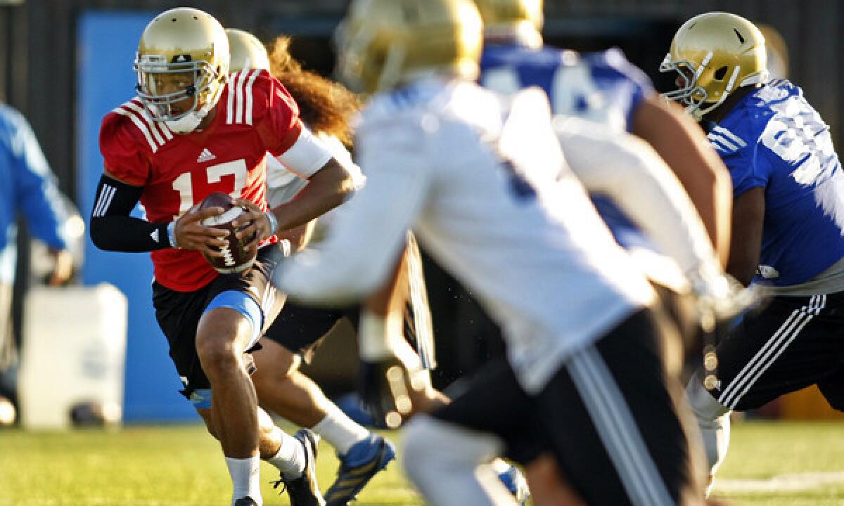 UCLA quarterback Brett Hundley carries the ball during a morning practice session April 1. The Bruins had some out of town visitors at their practice Monday.