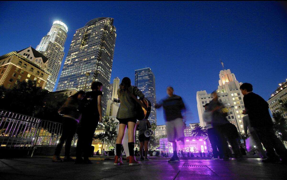 A music concert draws a small crowd to Pershing Square as dusk descends on Los Angeles. Recent data indicate that the leasing market for office space is on the upswing.