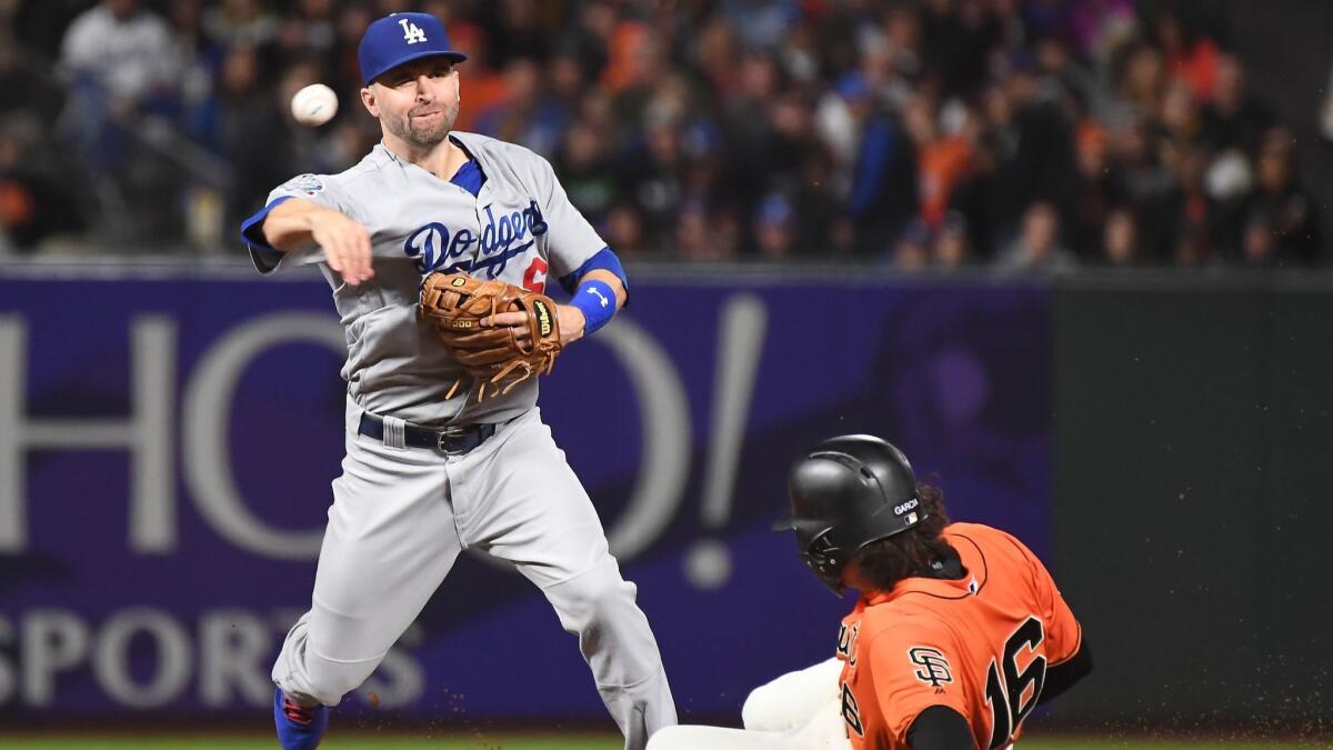 Dodgers second baseman Brian Dozier forces out San Francisco Giants' Aramis Garcia to complete a double play in the second inning at AT&T Park in San Francisco on Friday.