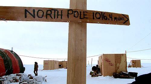 A sign stands on a mile-wide Arctic ice floe that serves as a temporary camp for Navy personnel conducting submarine research. The Navy, every few years, builds a temporary ice camp like this one to run submarine war games. When the games end a month or so later, the Navy removes the equipment and burns the camp.