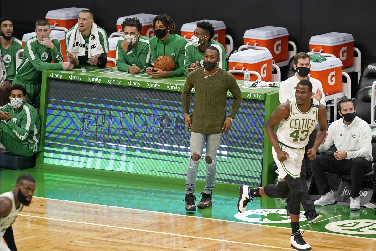 Jugadores de los Celtics de Boston siguen las acciones desde la banca en el duelo ante los Wizards